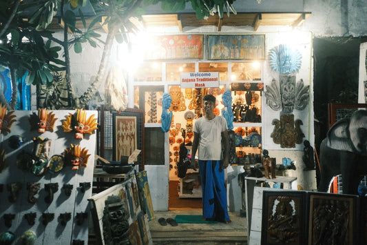 A man standing in front of a store at night