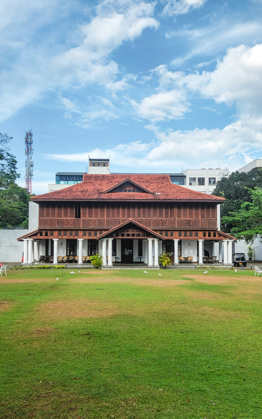 A large building with a red roof in the middle of a field