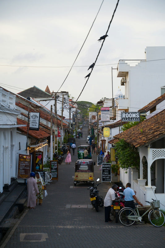 A narrow street in a busy, coastal town.